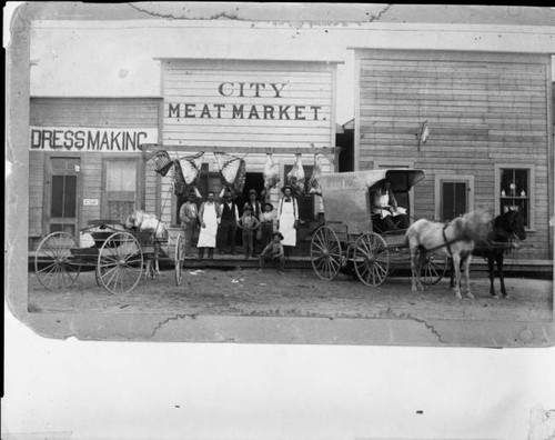 Horse drawn wagons outside of City Meat Market