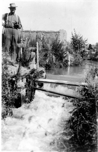 Workers Watching Water Flowing Through Irrigation Gate