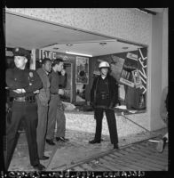 Police officers guard a looted store in Watts, Los Angeles (Calif.)