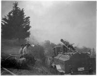 Fire fighting crew uses a small bulldozer to clear brush after a fire in La Canada, Los Angeles, October 1945