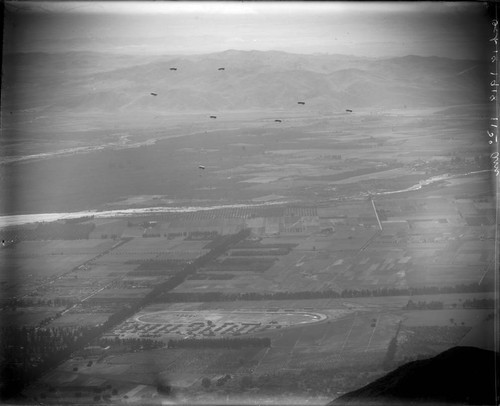 Telephoto view from Mount Wilson of parachutes over Santa Anita Park, Arcadia