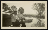 Man and young boy sitting by the river