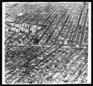 Low-altitude aerial view of the Miracle Mile, looking north over Wilshire Boulevard, showing the Park La Brea apartments, 1957