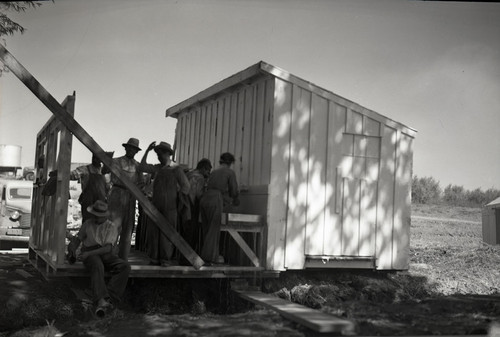 Several Mexican workers at wash basin in labor camp