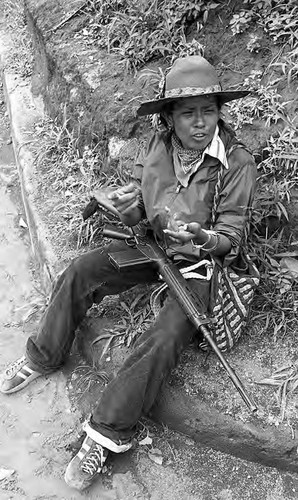 A Sandinista woman sits on a curb, Nicaragua, 1979