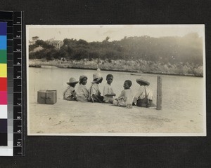 Group of boys seated on dockside, Eleuthera, Bahamas, ca. 1930