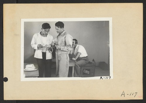 Poston, Ariz.--George Kita (left) and Norris James, WRA official, in an interview at this War Relocation Authority center during a CBS nationwide hookup. Photographer: Clark, Fred Poston, Arizona