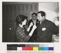 An unidentified woman explaining something to two unidentified men