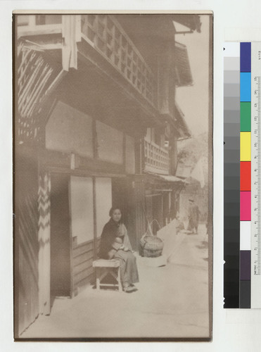 [Seated woman outside building in Chinatown, San Francisco]