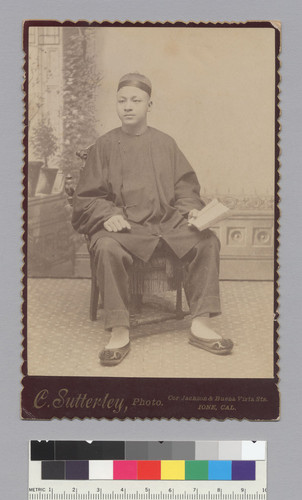 [young man seated holding a book]