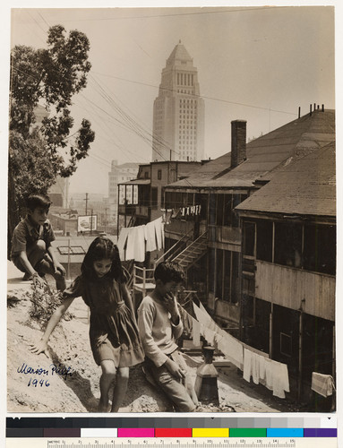 Three children playing behind houses in Boyle Heights