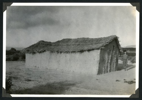 House in El Rosario showing waddle and dab construction with Warren Thornthwaite, standing