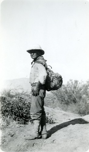 Abram Jat'ám carrying pots in a mescal net