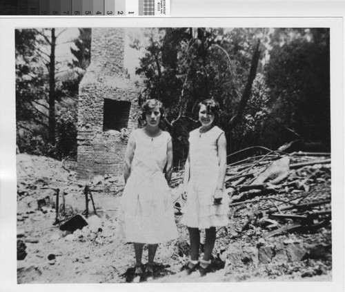 Clarissa Young Byrnes and Dorothy Greg in front of a burned home