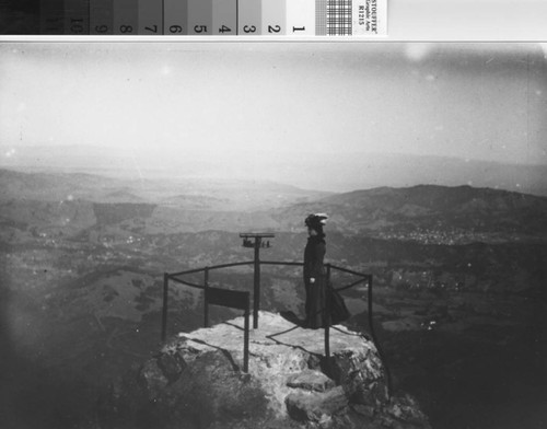 Woman and telescope atop the summit of Mount Tamalpais, East Peak