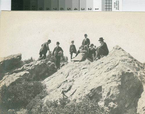 A group of hikers atop a lookout rock