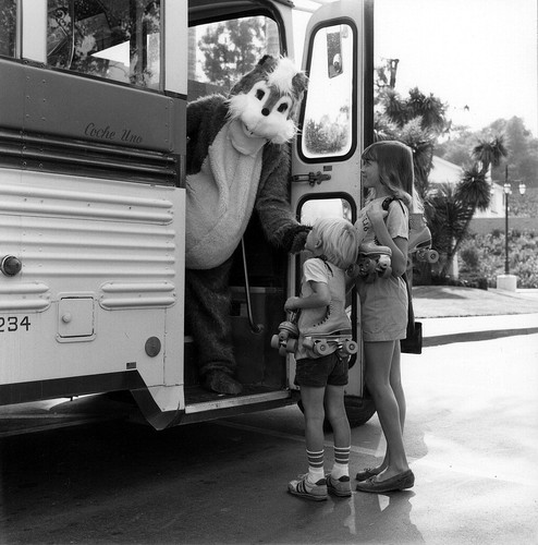 [Mission Viejo Skateway mascot, Rocky Roller, greets children at door of bus, 1981 photograph]