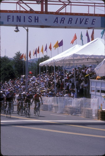 [1984 Olympics Women's Cycling Road Race with cyclists racing by spectators' grandstand slide]