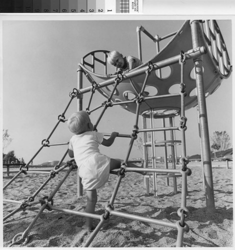 [Two children on playground equipment photograph]