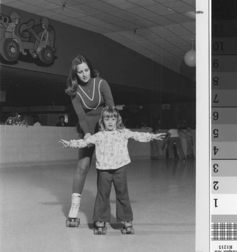 [Woman and young girl on roller skates photograph]