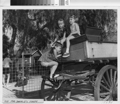 [Old MacDonald's Farm wagon with three girls on it photograph]