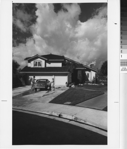 [Washing car and gardening in front of home photograph]