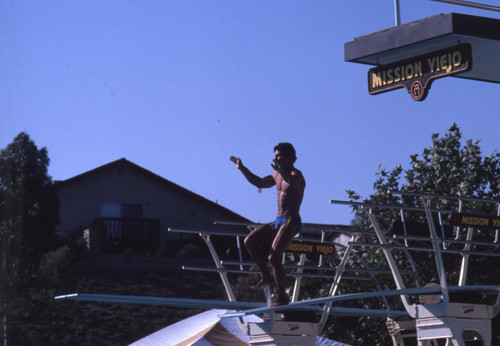 [Diver of the Mission Viejo Nadadores preparing to dive from diving board slide]