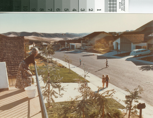 [Mission Viejo neighborhood with woman on balcony and children playing below in street, 1971 photograph]