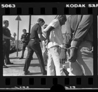 Los Angeles Southeast Division police officers arresting four male youths in Los Angeles, Calif., 1980