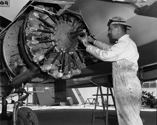 William H. Horton, working on a 450 horsepower radial position engine used on his wingless airplane, Orange County Airport, June 1953