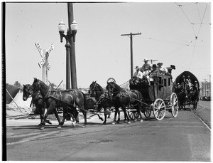 Stage coach and a Conestoga wagon near a railroad crossing