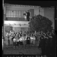 USC Delta Tau Deltas at UCLA Kappa Kappa Gamma sorority house serenade one another to celebrate couples pinning, 1964