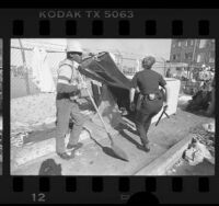 Homeless man being ousted from camper shell on Skid Row in Los Angeles, Calif., 1987