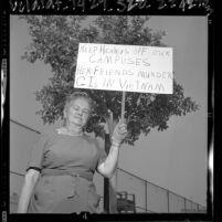 Woman holding placard stating "Keep Healeys Off Our Campuses..." in protest over Dorothy Healey's Cal State appearance, 1964