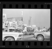 Street lined with storefronts and signs in Chinese and English in San Gabriel, Calif., 1987