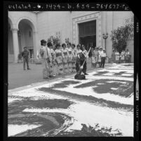 Ben Ogomori making 50 foot poster in Japanese calligraphy as Nisei Week queen contestants watch in Los Angeles, Calif., 1970