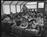 School children diligently read while their teacher watches from the back of their makeshift classroom, Los Angeles, 1935