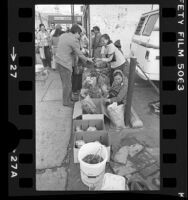 Vietnamese street vendors selling produce outside Mah Wah market in Chinatown, Los Angeles, Calif., 1982