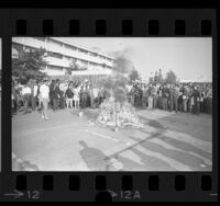 Anti-war demonstrators watching burning of napalm coated mannequin on Cal State Los Angeles campus, 1967