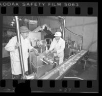 Irving Geldin and Harry Segal watching mechanical meat deboning machine at Geldin Meats in Vernon, Calif., 1976