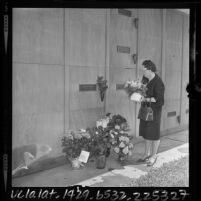 Woman placing flowers at tomb of Marilyn Monroe on second anniversary of Monroe's death, Westwood, Calif., 1964