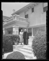 Dr. and Mrs. Elmer Ellsworth Helms standing on the porch of the home given to them by First Methodist Church in Los Angeles, Calif., 1948