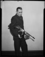 Vince Higgins, an investigator for the District Attorney, holds a machine gun, Los Angeles, 1935