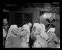 Bishop Asaiah comforts one of the sisters of Fountain of the World at a prayer meeting in comemoration of the bombing that killed sect leader Krishna Venta along with nine others, 1958