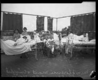 Miss Florence Mast and sick children at Los Angeles County General Hospital pose on a sun terrace, Los Angeles, 1934