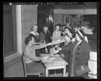 Thomas Heeney hands out applications for enlistment in Women's Army Auxiliary Corps (WAAC) in Los Angeles, Calif., 1942