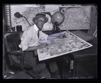 Los Angeles Times Illustrator Charles Owens at his desk working, Los Angeles, circa 1920