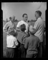 Comedian Bob Hope talking to reporter as children look on at Los Angeles Times War Workers Golf Tournament, 1943