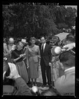 Rita Hayworth and estranged husband Aly Kahn surrounded by reporters outside Hayworth's home, 1952