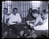 Murder suspect David H. Clark playing cards with other prisoners in jail cell in Los Angeles, Calif., 1931